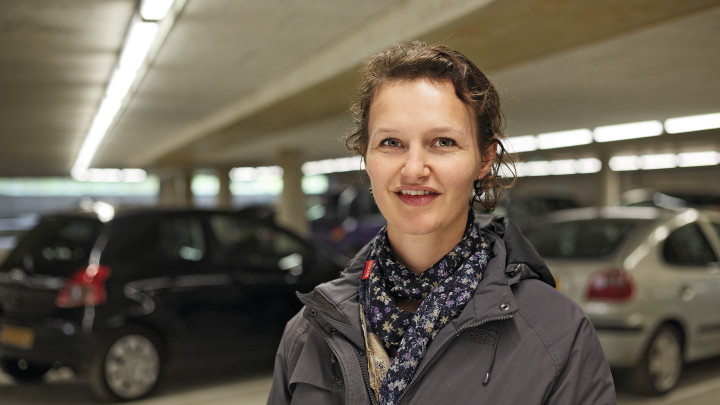 在使用飛利浦照明的 Eiteren 停車場內，幾位女士在一些車輛前方微笑