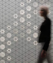 女子走過裝飾飛利浦 Luminous Patterns 的室內牆面 - 顧客體驗
