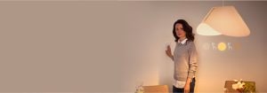 “女性調節智慧調光開關，在簡約裝飾的現代生活空間中控制溫暖的 LED 照明氛圍”
