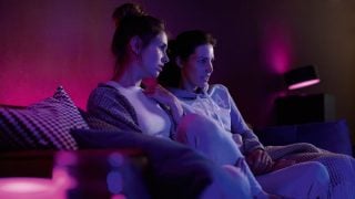 Philips Hue 智慧 LED 燈在客廳營造出充滿活力的紫色和粉紅色氛圍，為現代家庭的電影之夜和放鬆展示可客製化的氛圍照明。