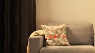 “舒適的客廳配有現代 LED 檯燈、明亮的灰色雙人沙發，營造出家庭放鬆的溫馨氛圍。”